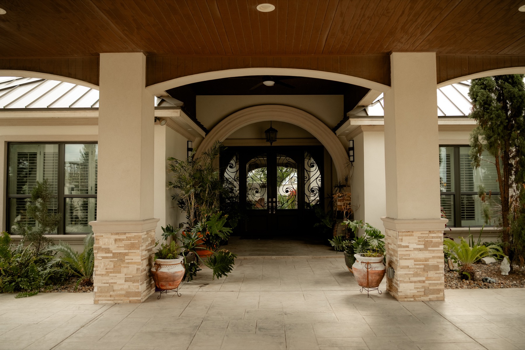 Grand covered entrance with wrought-iron doors