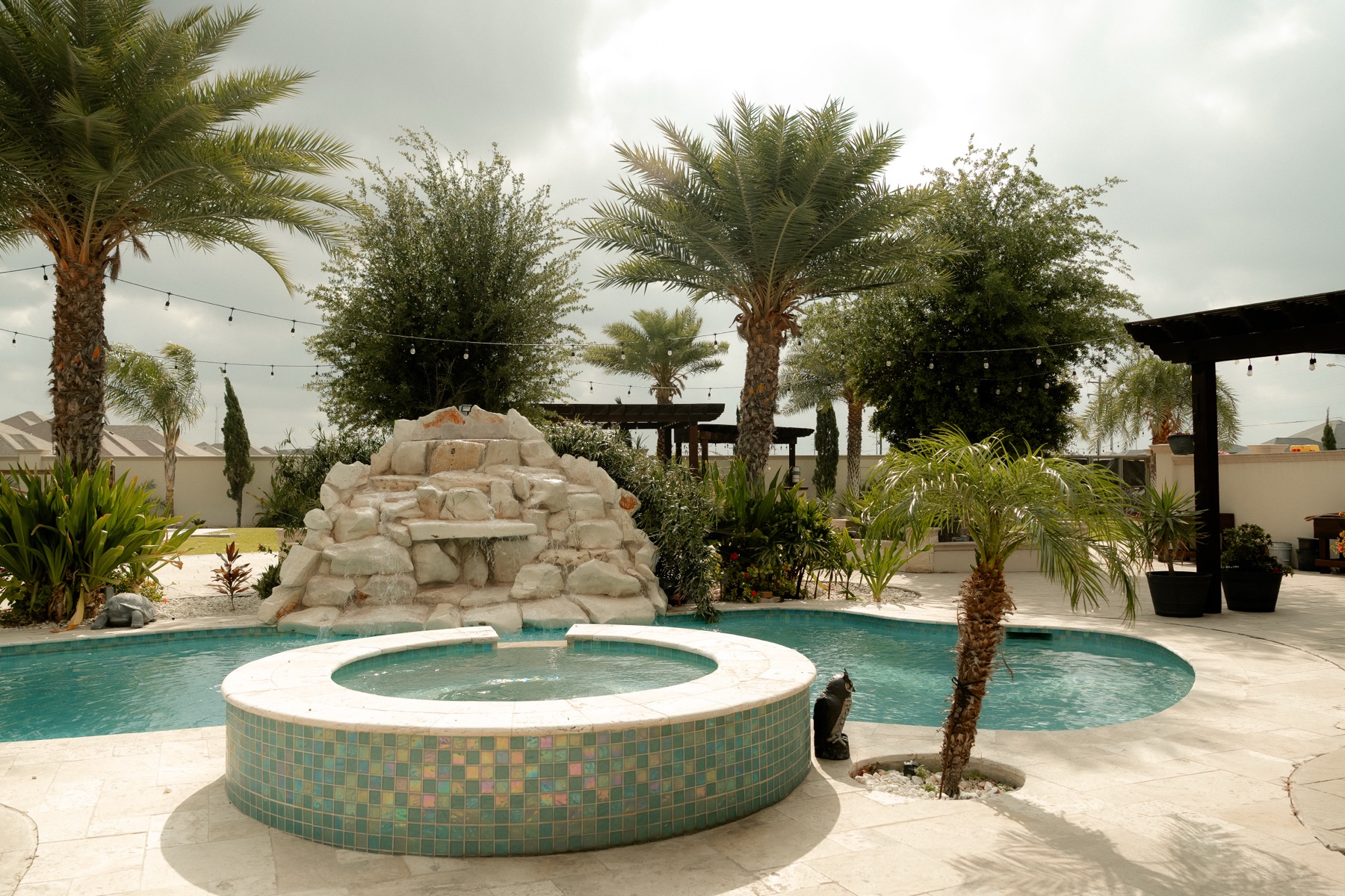 Pool fountain framed by palm trees