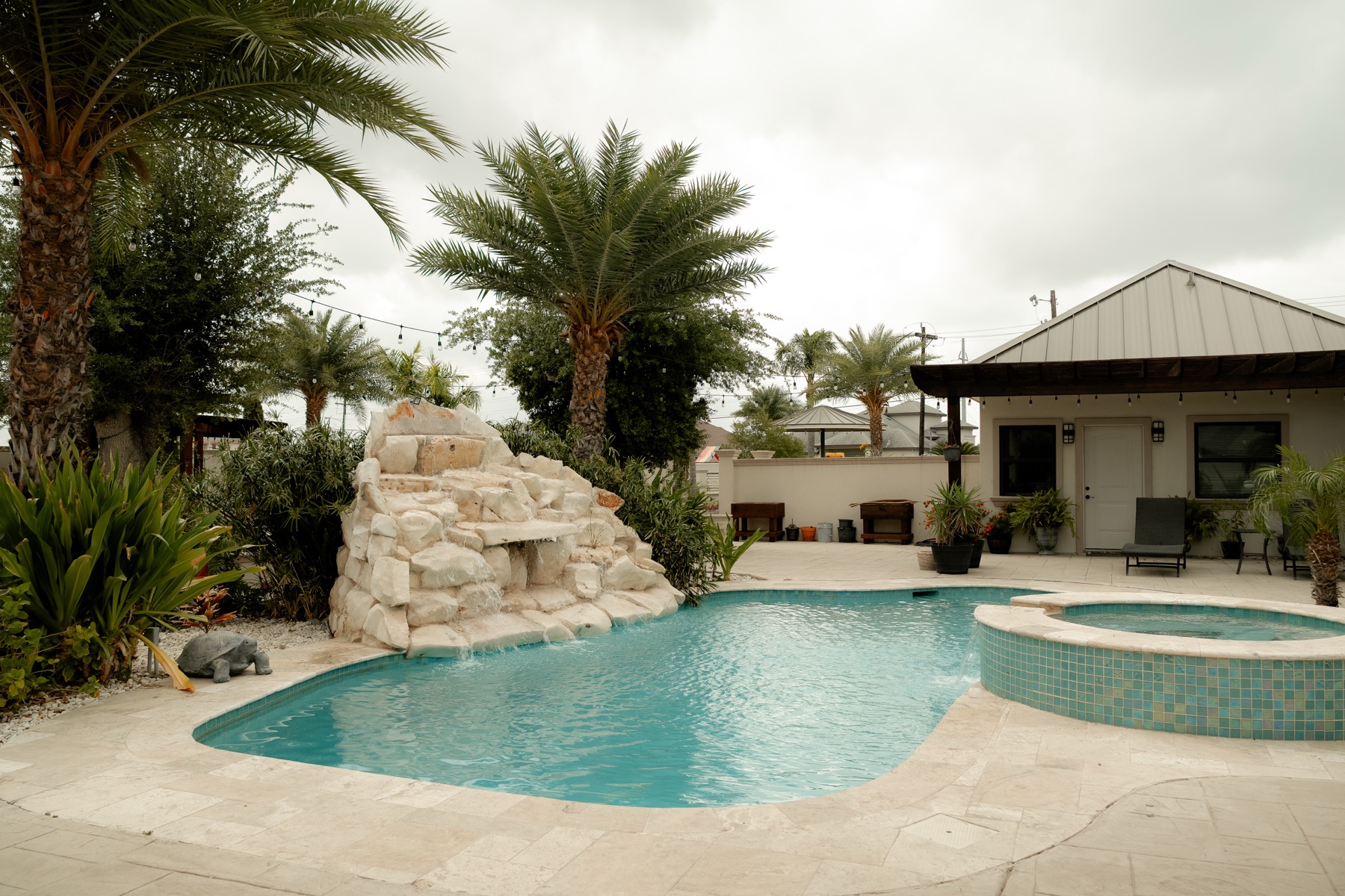 Pool with stone waterfall surrounded by palms