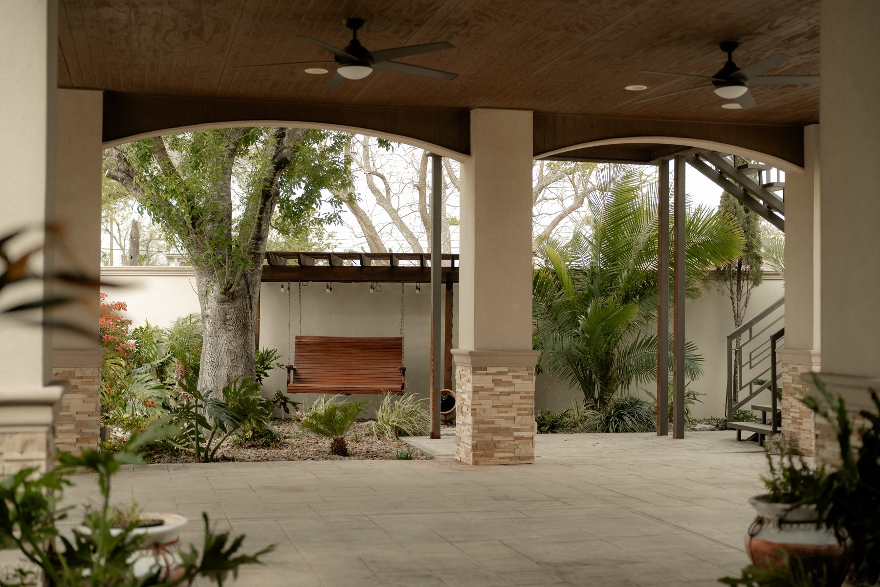 Covered pavilion with wooden swing and arched columns